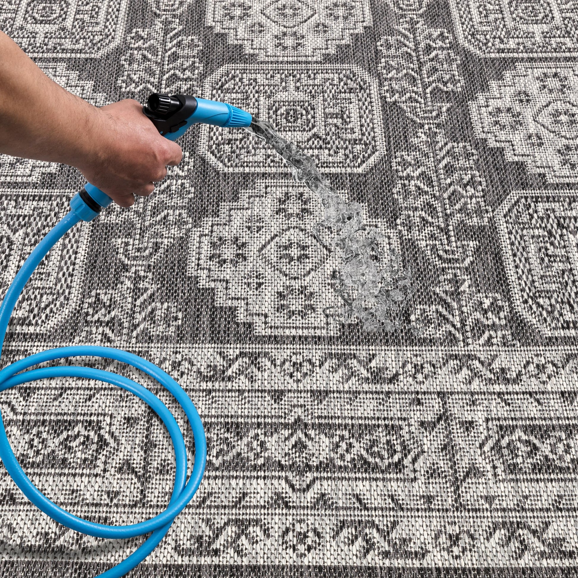Black Anatolian patio rug under bistro table with chairs