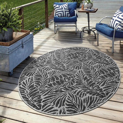 Black weatherproof botanical rug on cedar deck with lounge chairs