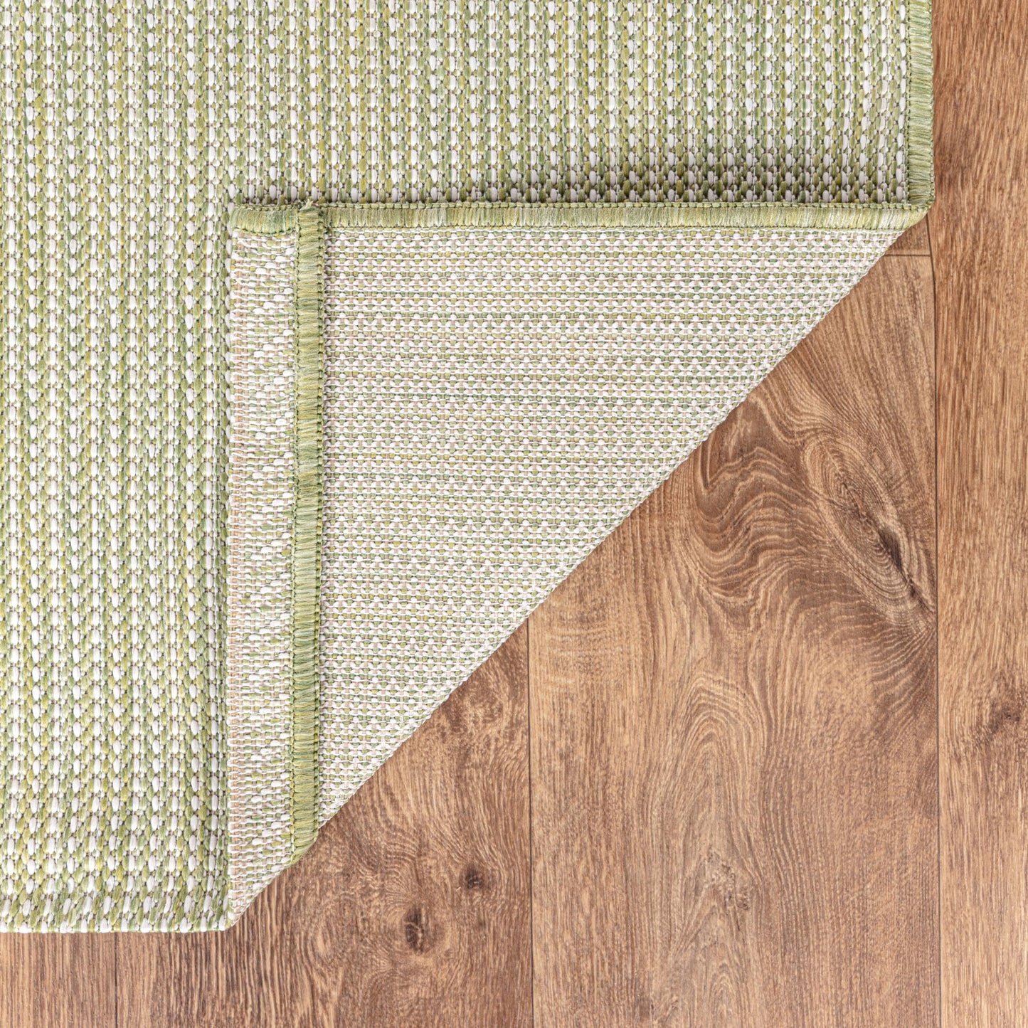 Solid green weatherproof rug beside swimming pool