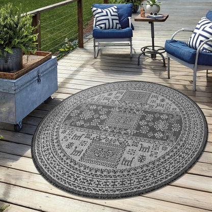 Black weatherproof tribal rug on cedar deck with lounge chairs